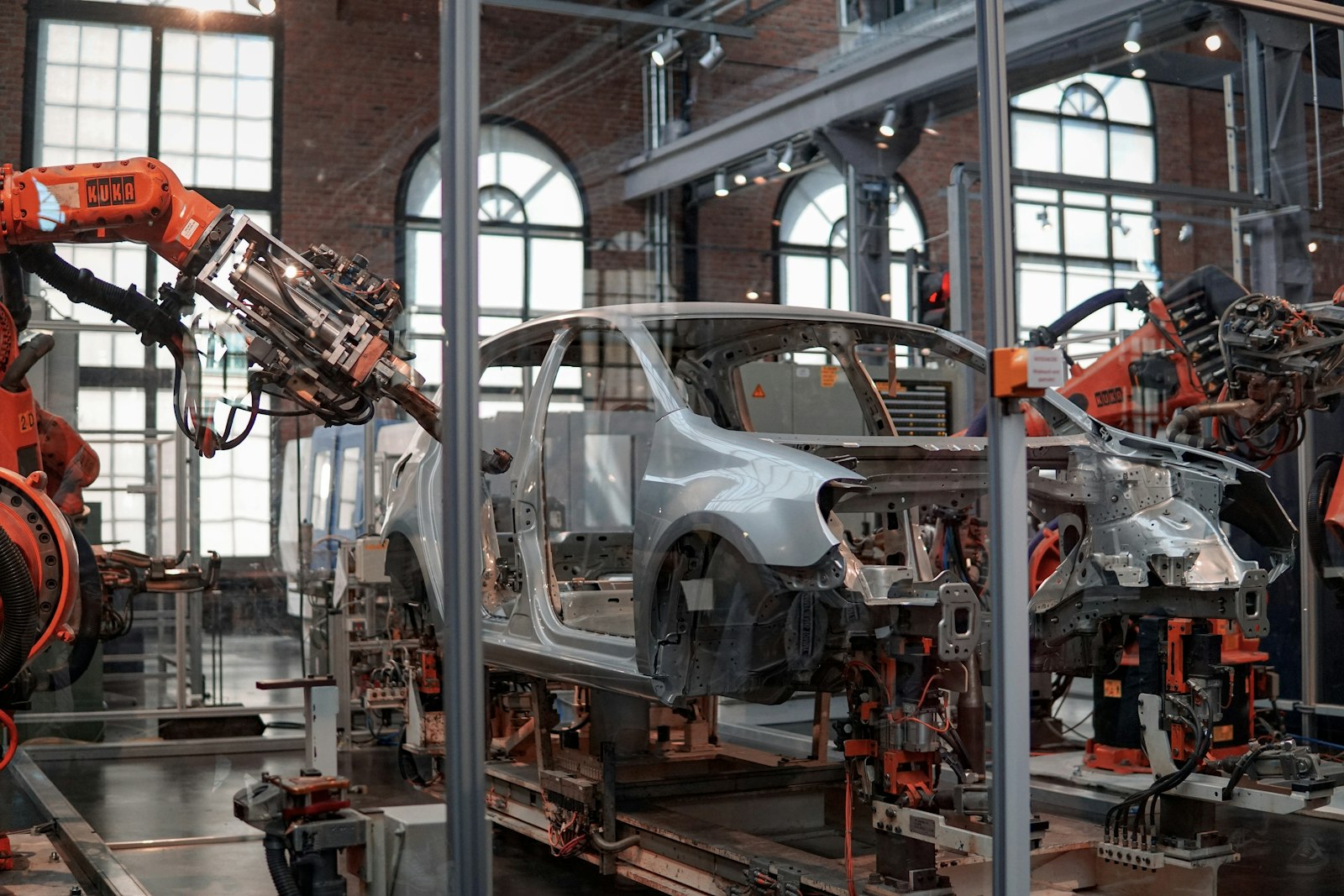 Robotic arms working on a vehicle body inside an automotive assembly plant