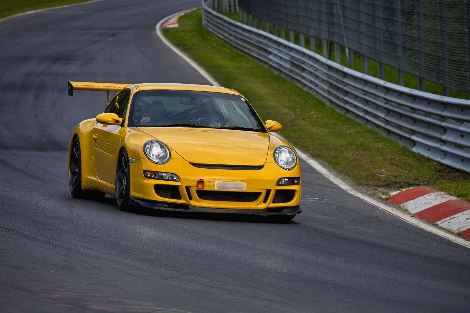 Yellow Porsche 911 GT3 cornering on a race track