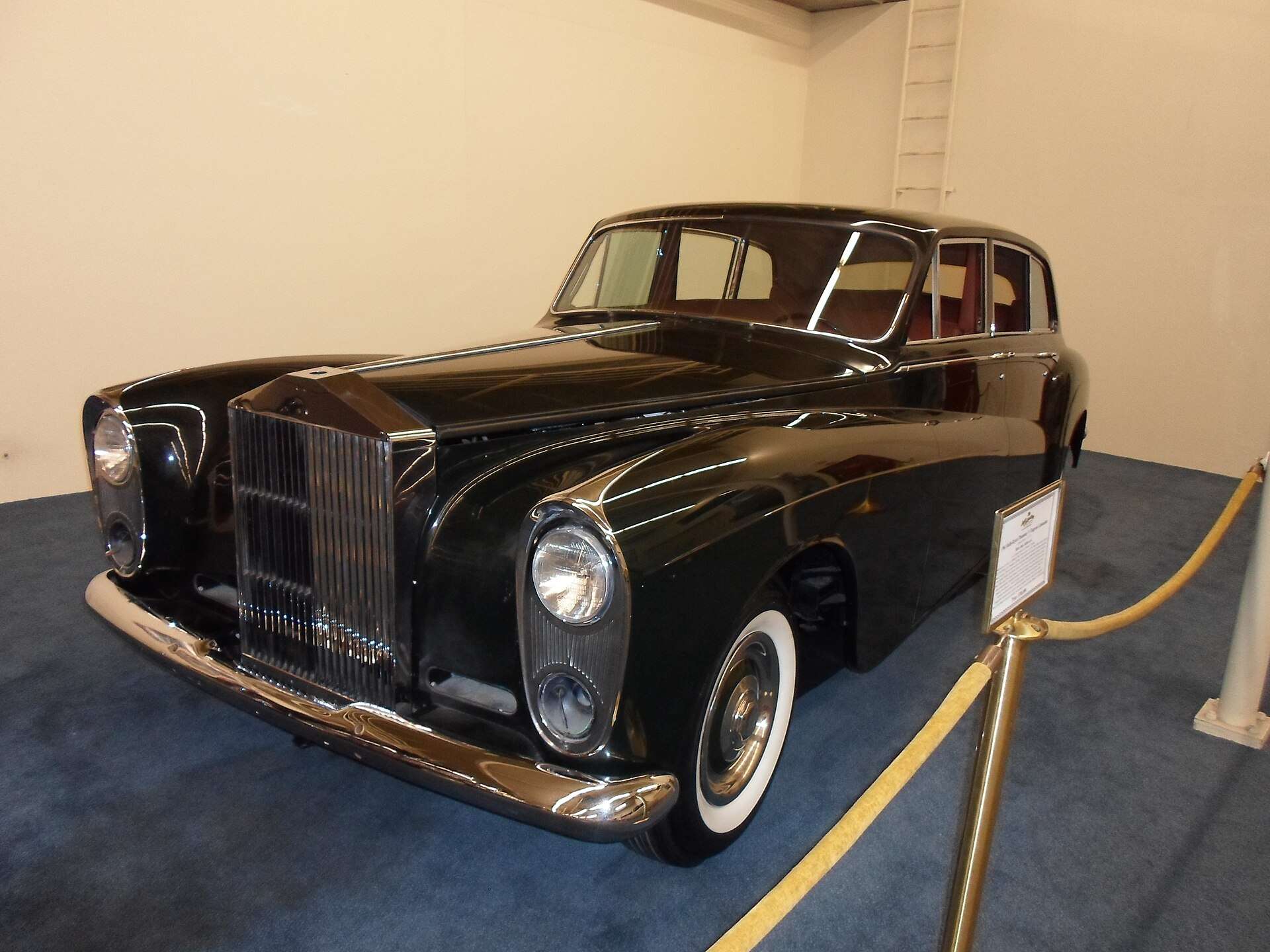 A dark 1961 Rolls-Royce Phantom V limousine on display indoors