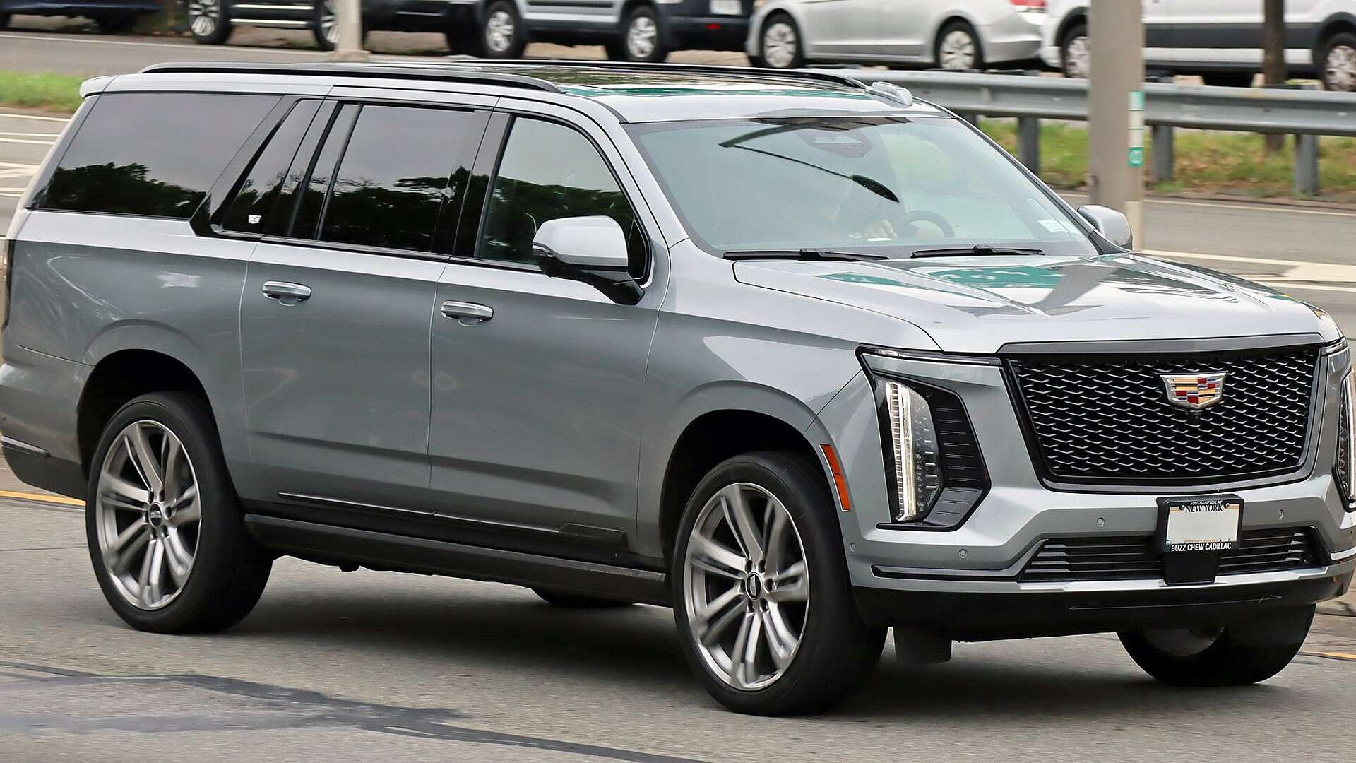 Gray 2025 Cadillac Escalade ESV parked on a city street, front three-quarter view