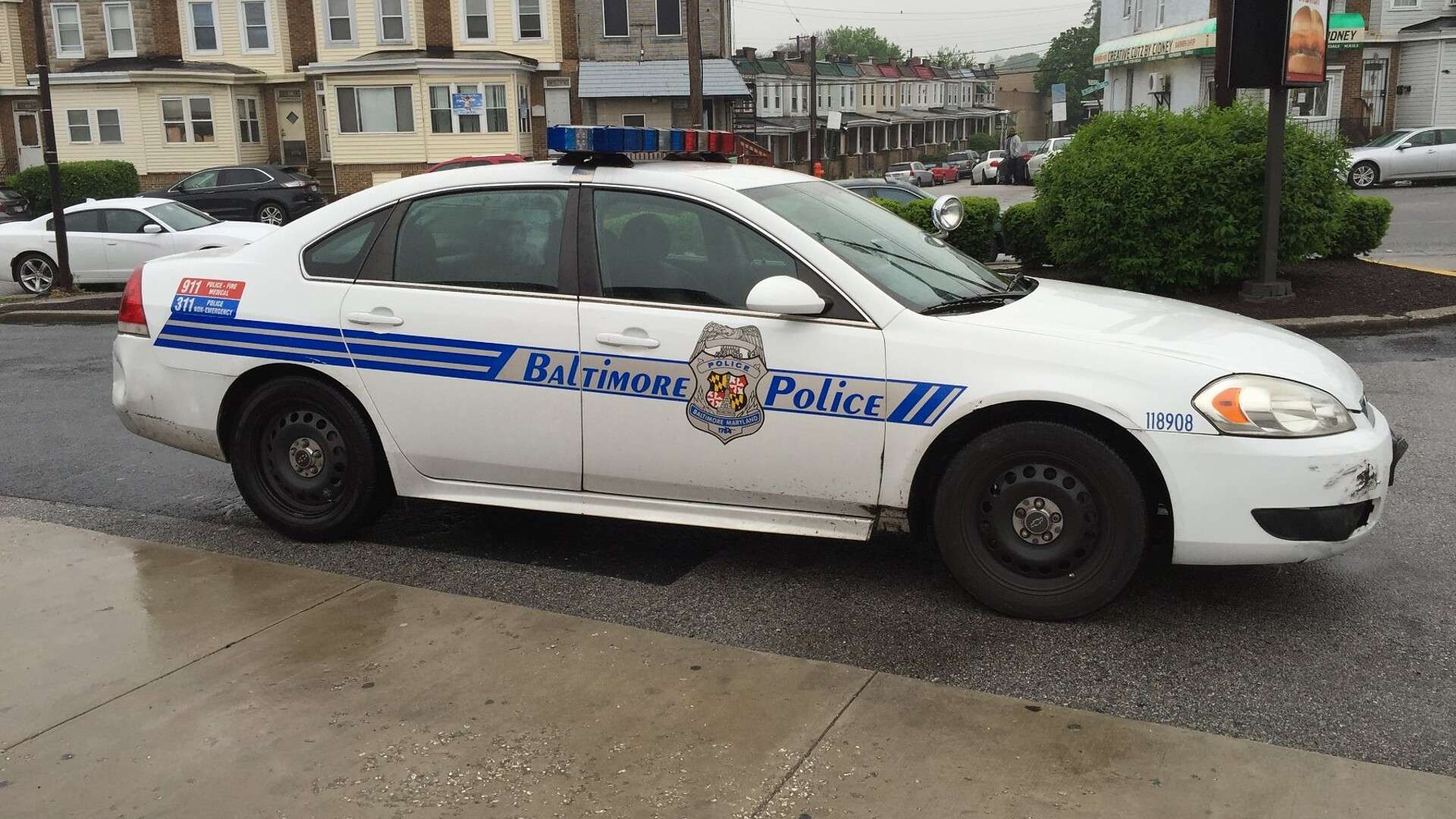 Baltimore Police patrol car parked beside row houses in Baltimore