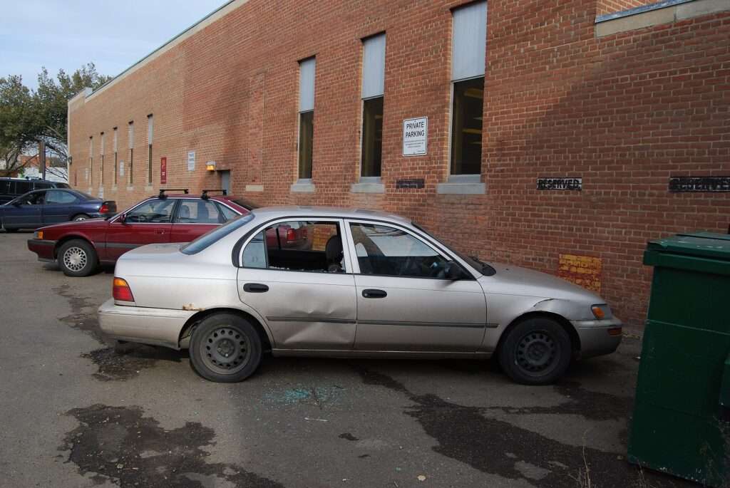A sedan with a shattered side window after a break-in