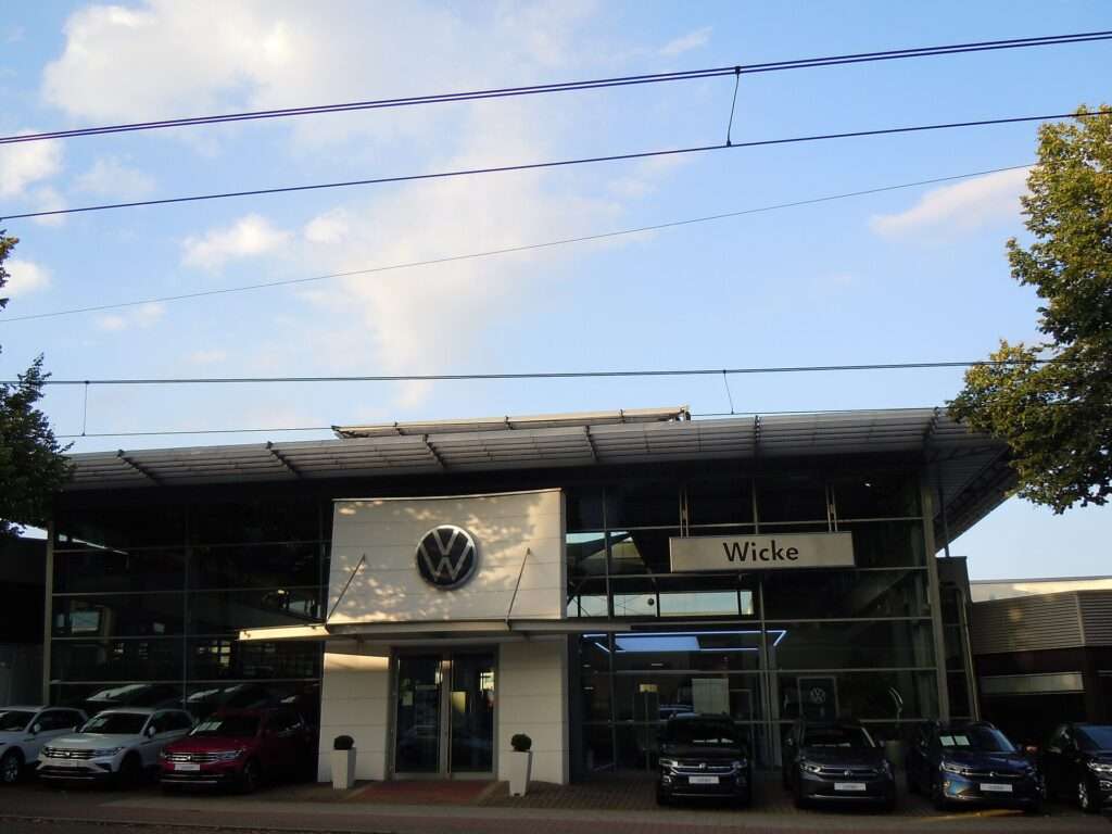 Volkswagen dealership showroom in Bochum-Linden, Germany, with new cars parked out front