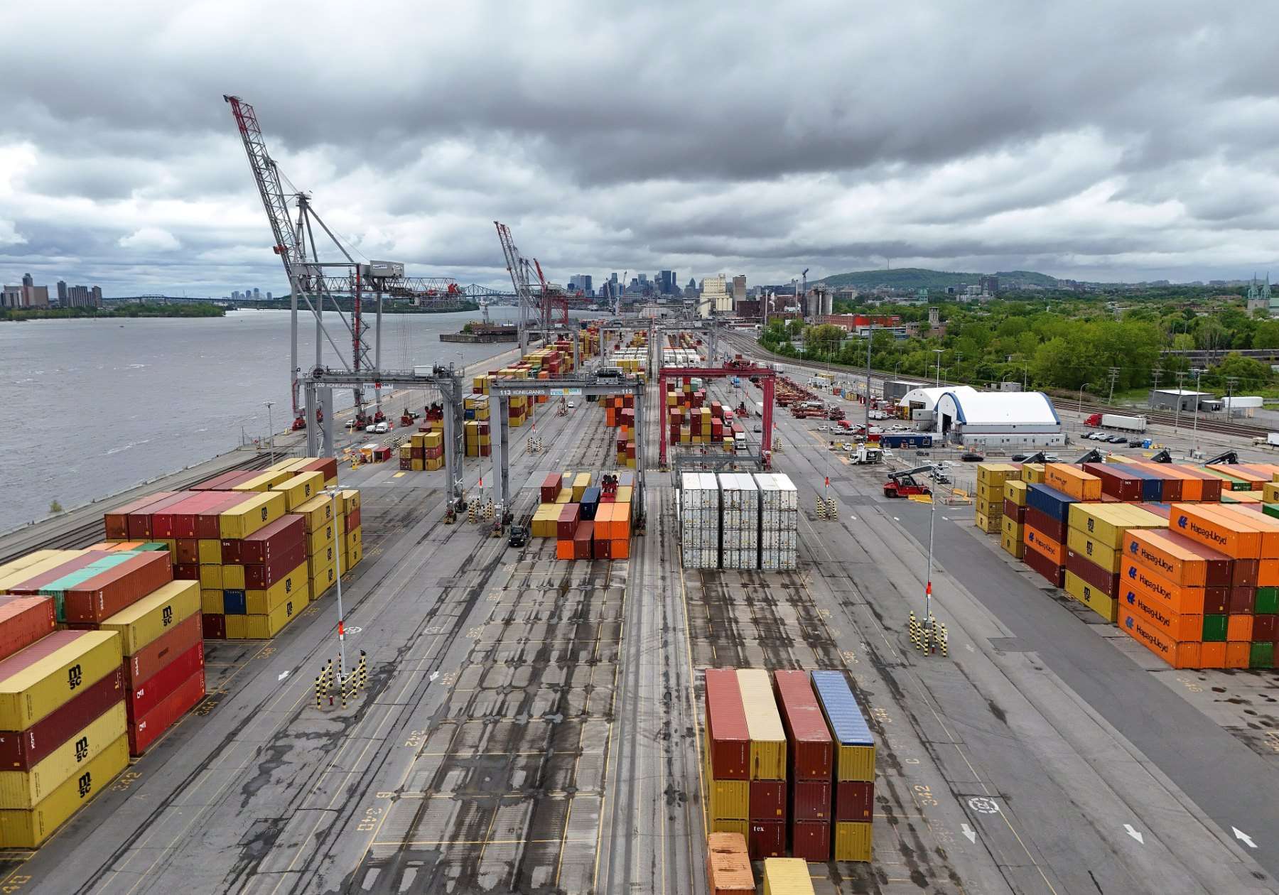 Stacks of shipping containers and cranes at a Port of Montreal terminal