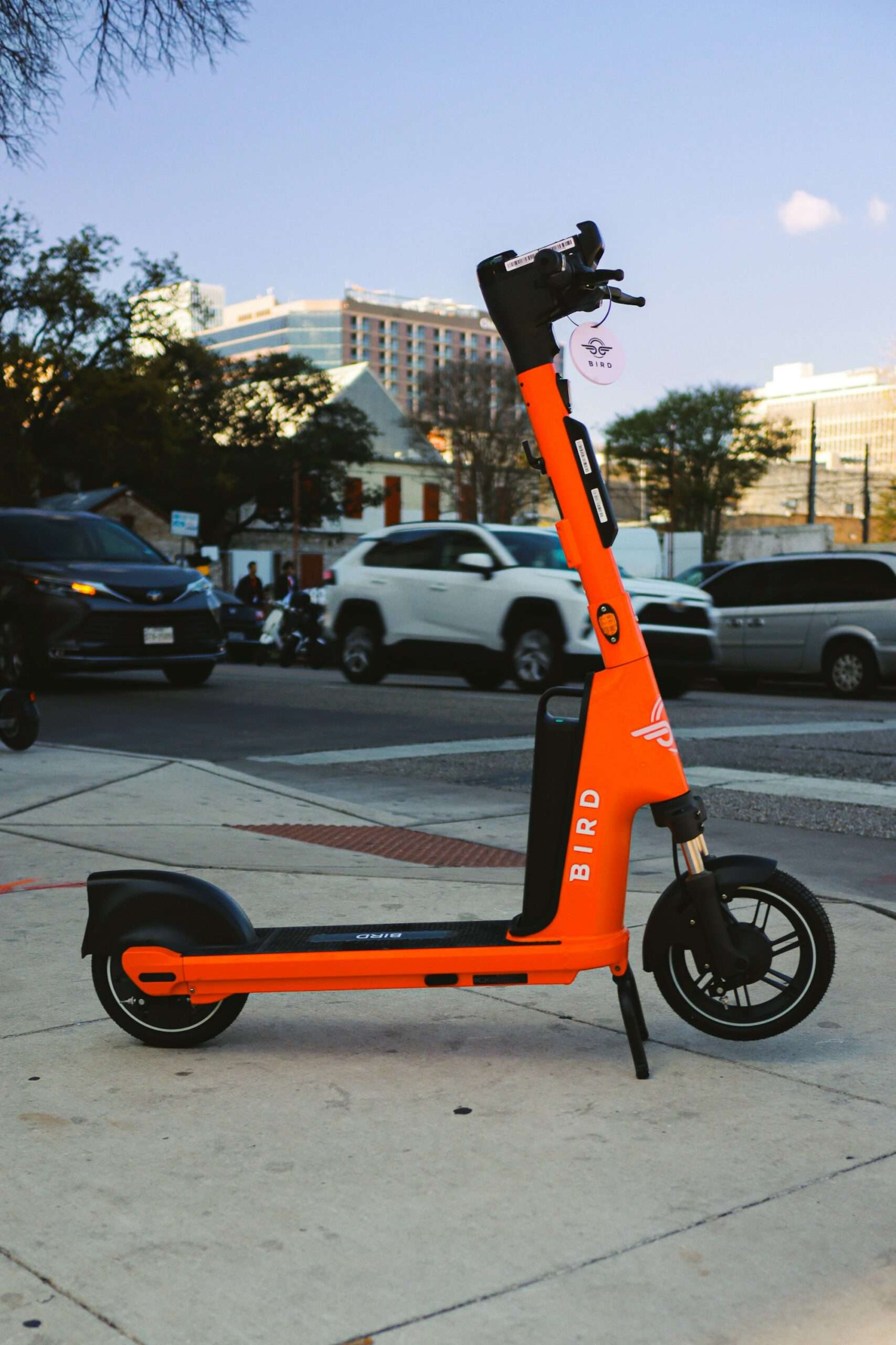 Orange electric scooter parked on a city sidewalk