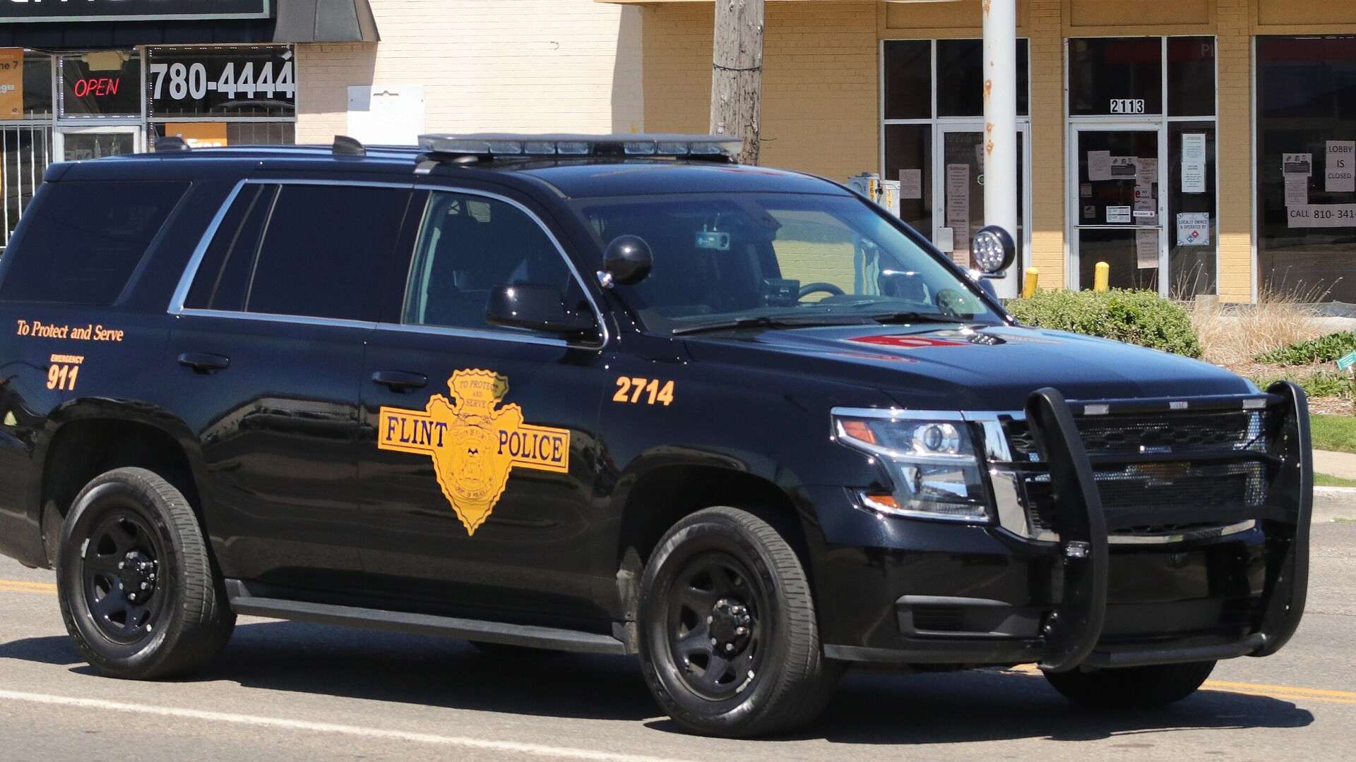 Black Flint police Chevrolet Tahoe patrol vehicle parked on a city street