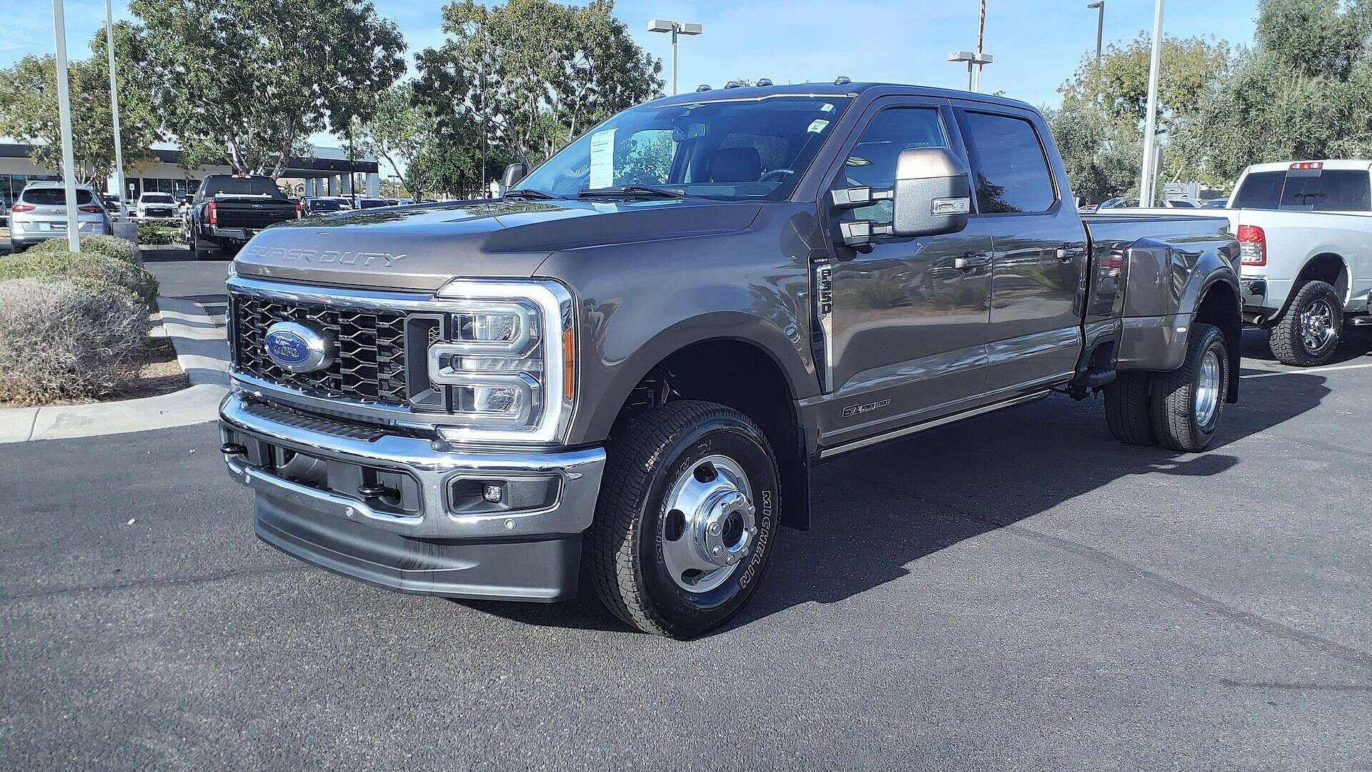 White 2023 Ford F-350 Super Duty Lariat crew cab pickup parked on a dealer lot