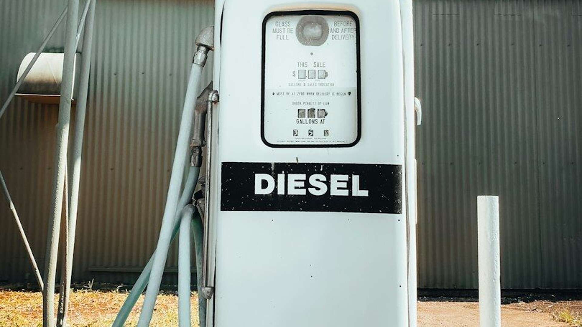 an old diesel gas pump with a hose hooked up to it