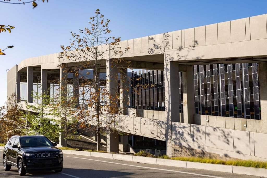 Exterior of the multi-level LAX Rental Car Center garage with a dark SUV driving past