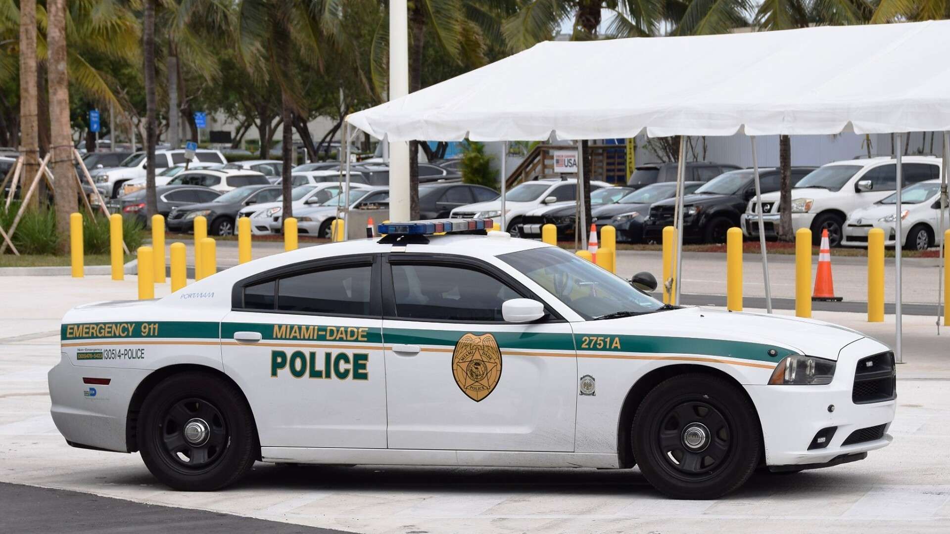A white Miami-Dade police Dodge Charger with green striping parked in a lot