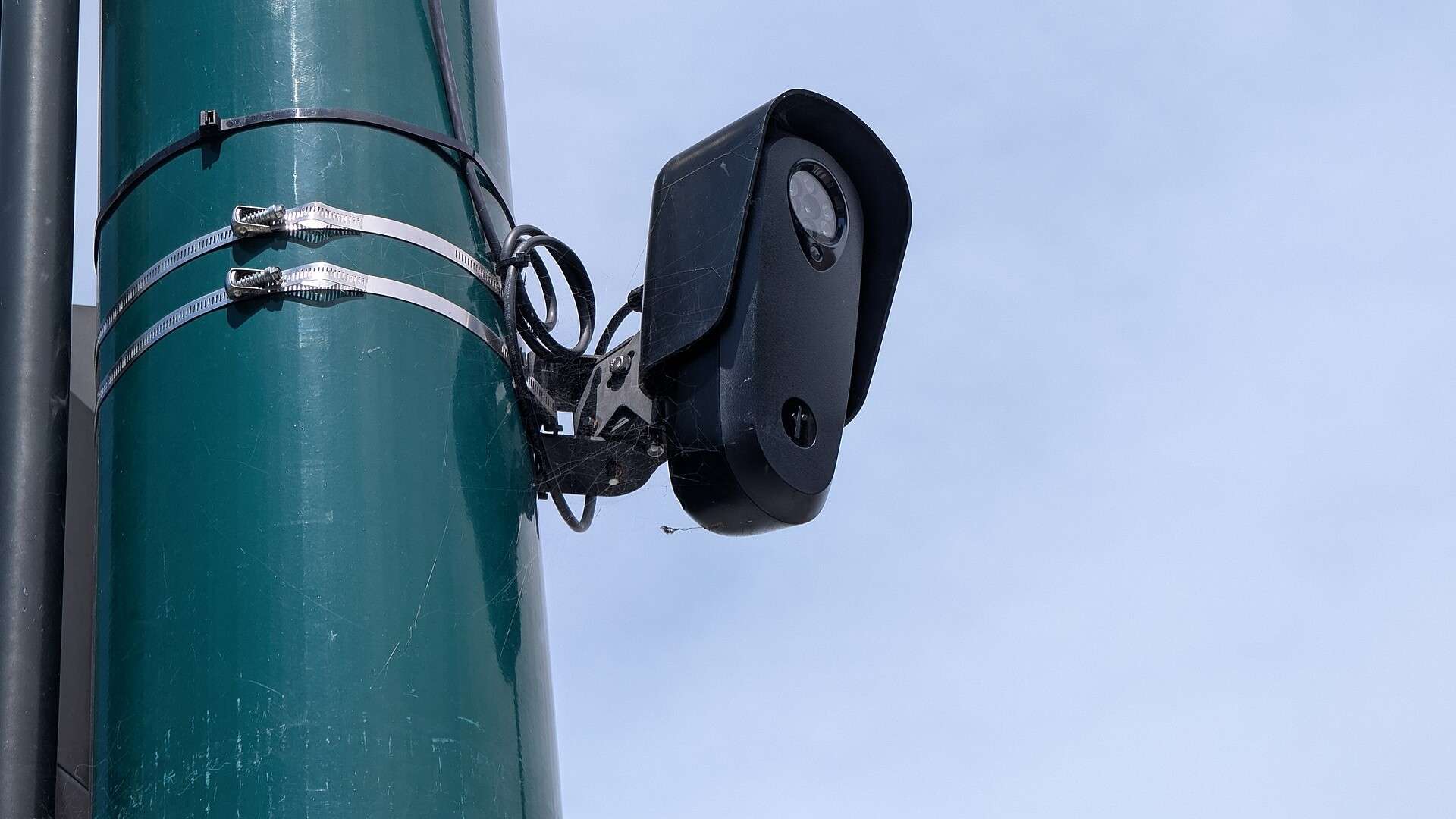 Roadside license plate reader camera mounted on a pole above a street intersection