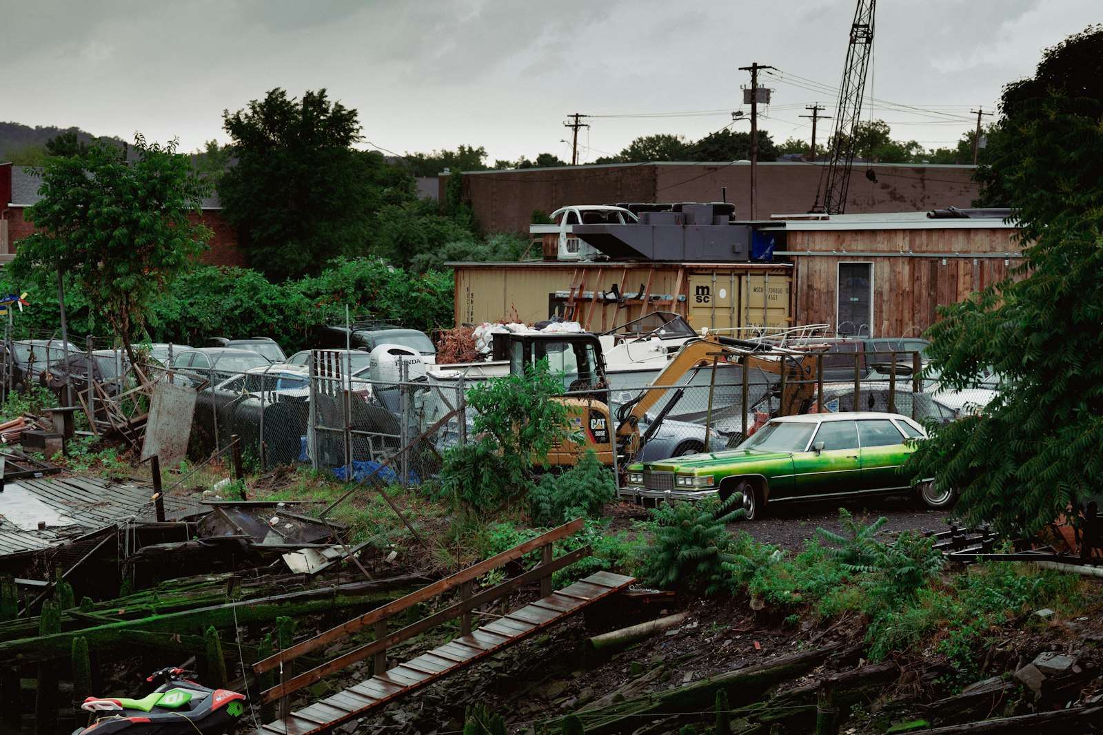 A scrapyard crowded with old cars, a loader and piles of scrap metal