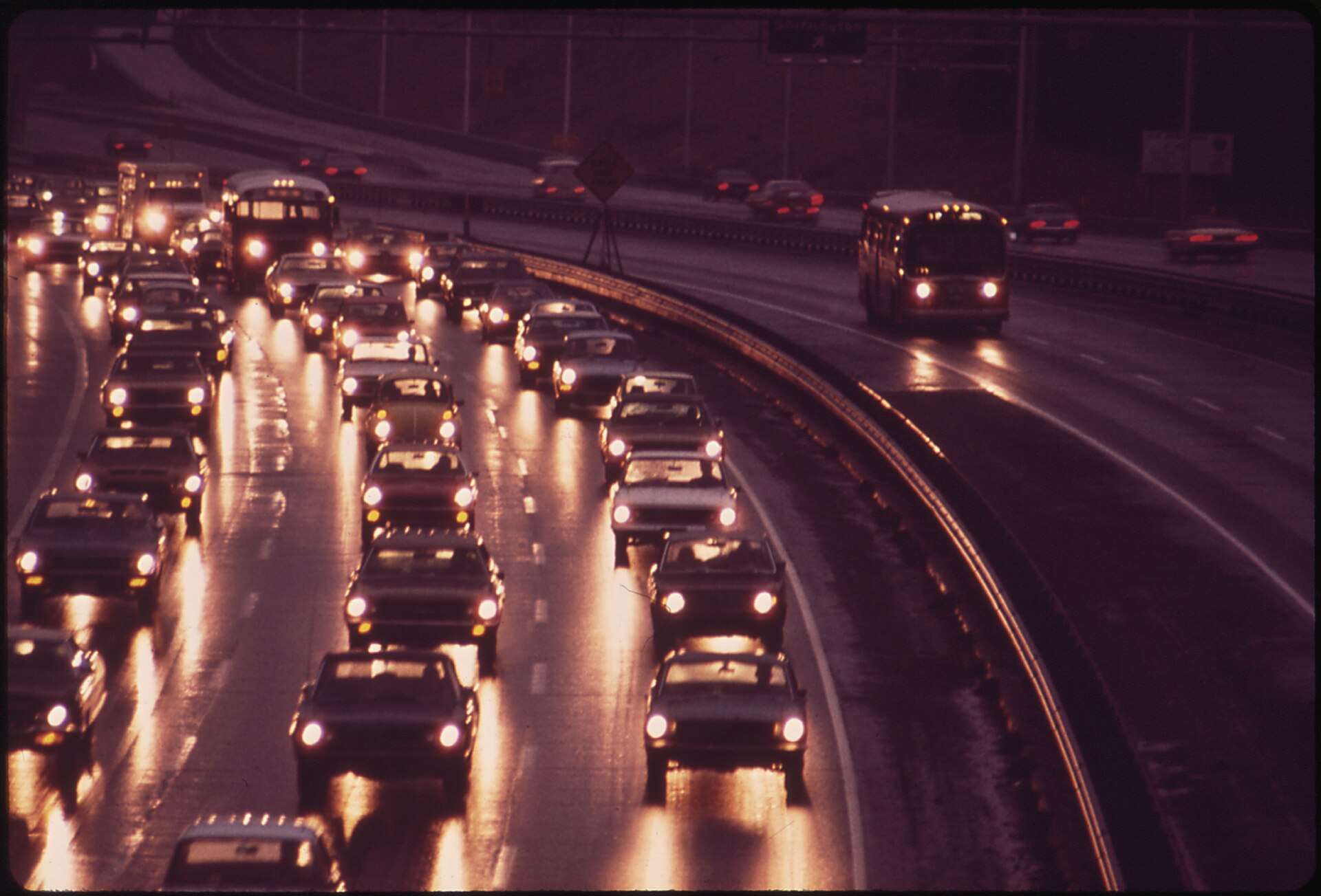 Dense evening rush-hour traffic with headlights on a curving multilane highway in Northern Virginia in 1973