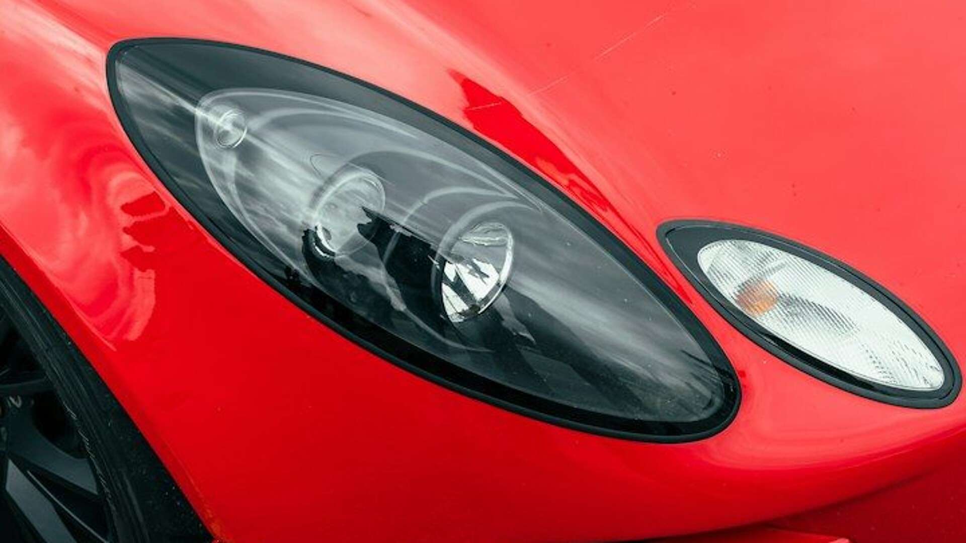 A red sports car parked in a parking lot
