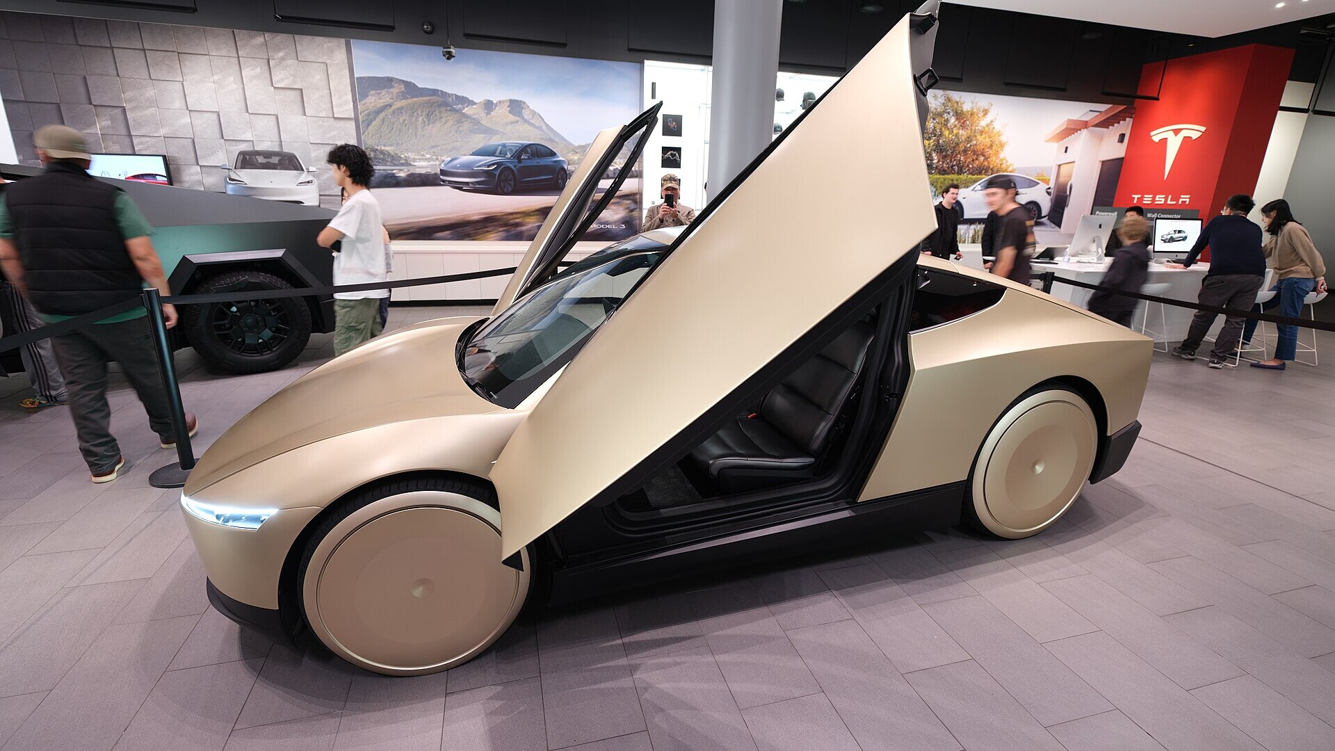 A two-door Tesla Cybercab robotaxi, which has no steering wheel or pedals, parked on display