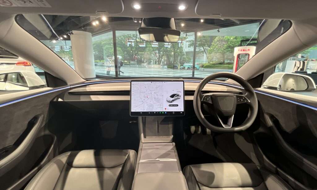Interior of a 2023 Tesla Model 3 showing the steering wheel and center touchscreen