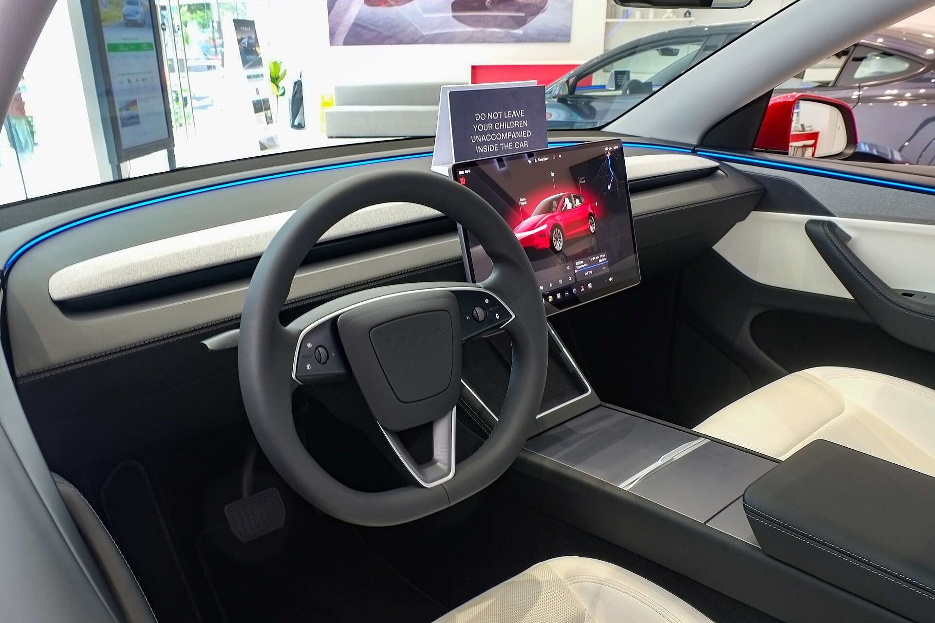 Interior of a 2025 Tesla Model Y showing the central touchscreen and steering wheel