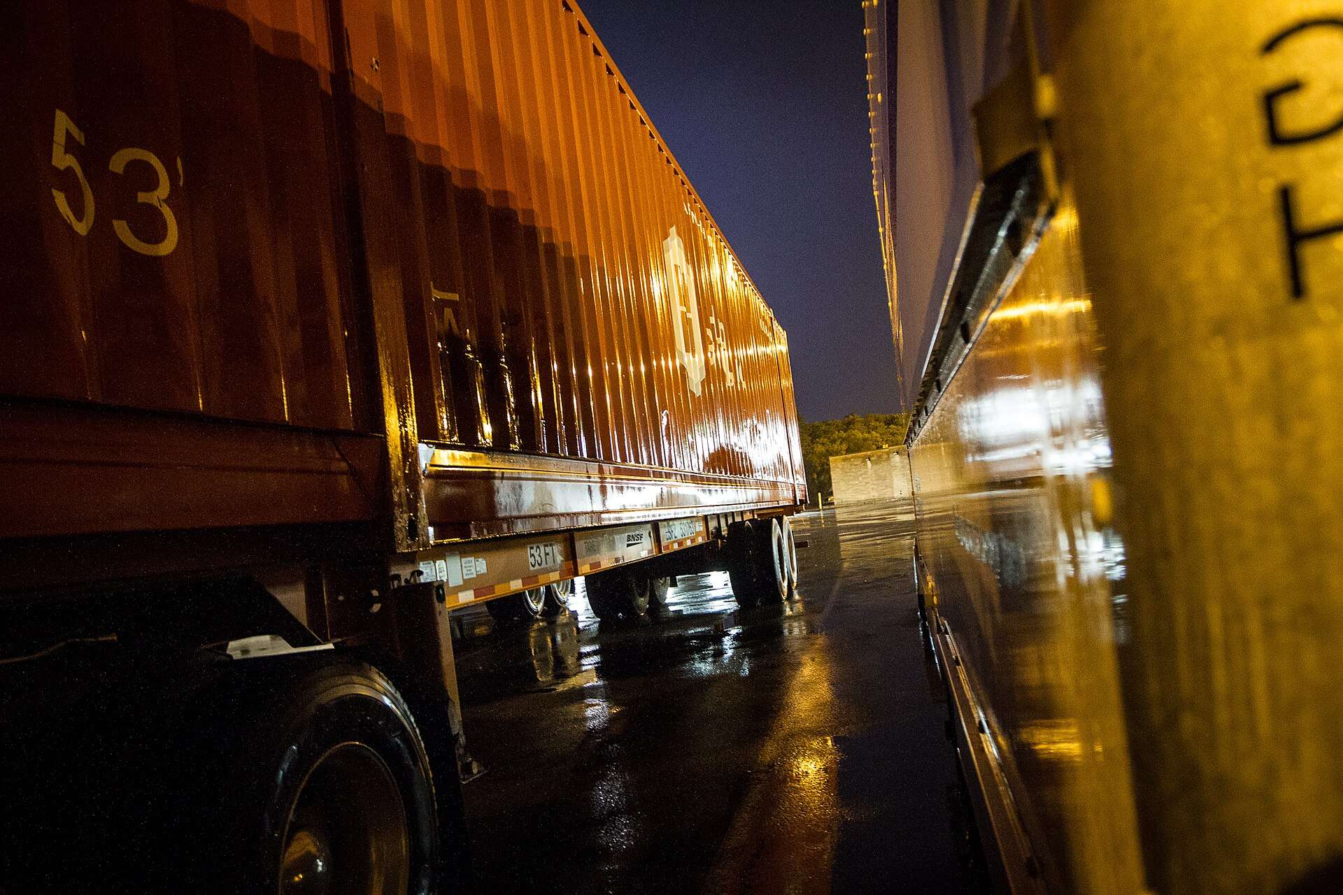 Semi-trailers parked at a rain-soaked truck stop in Portage, Indiana, at night