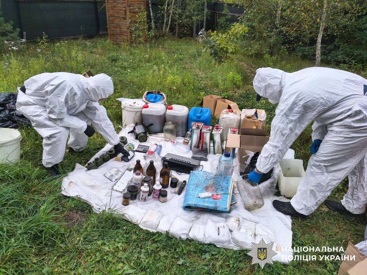 Investigators in white protective suits lay out bottles, containers and lab equipment seized during Operation Breaking Bad