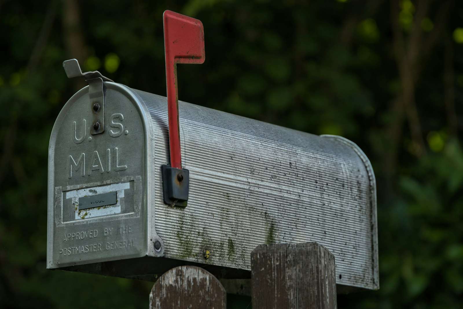 Weathered U.S. Mail roadside mailbox with its red flag raised