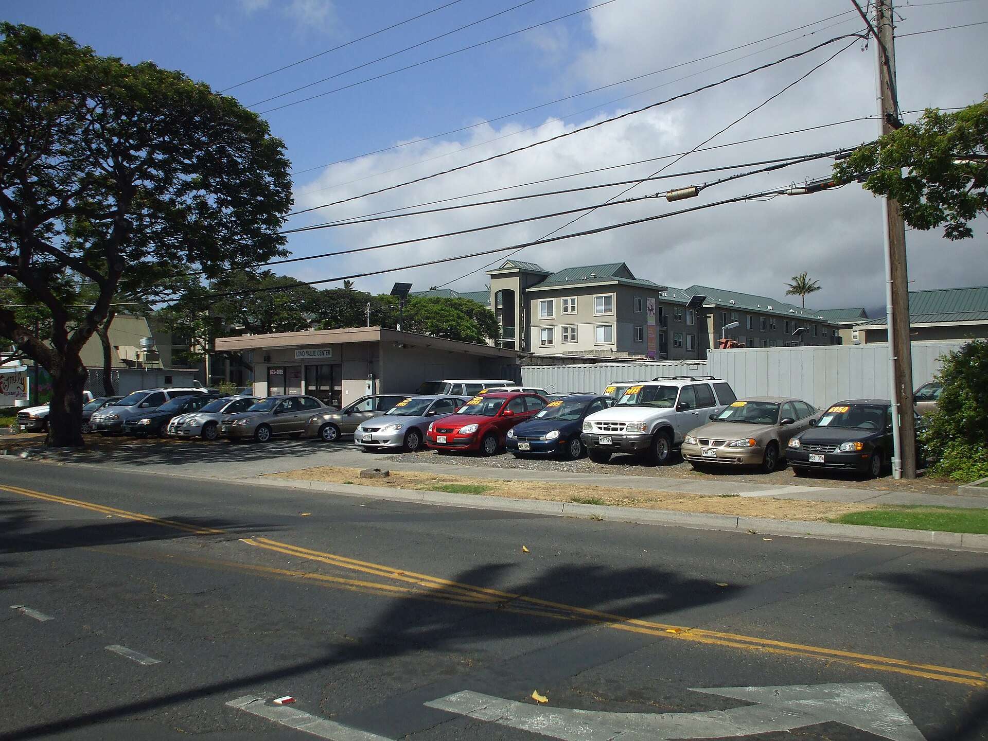 Rows of used cars with red and yellow price tags on a dealer lot