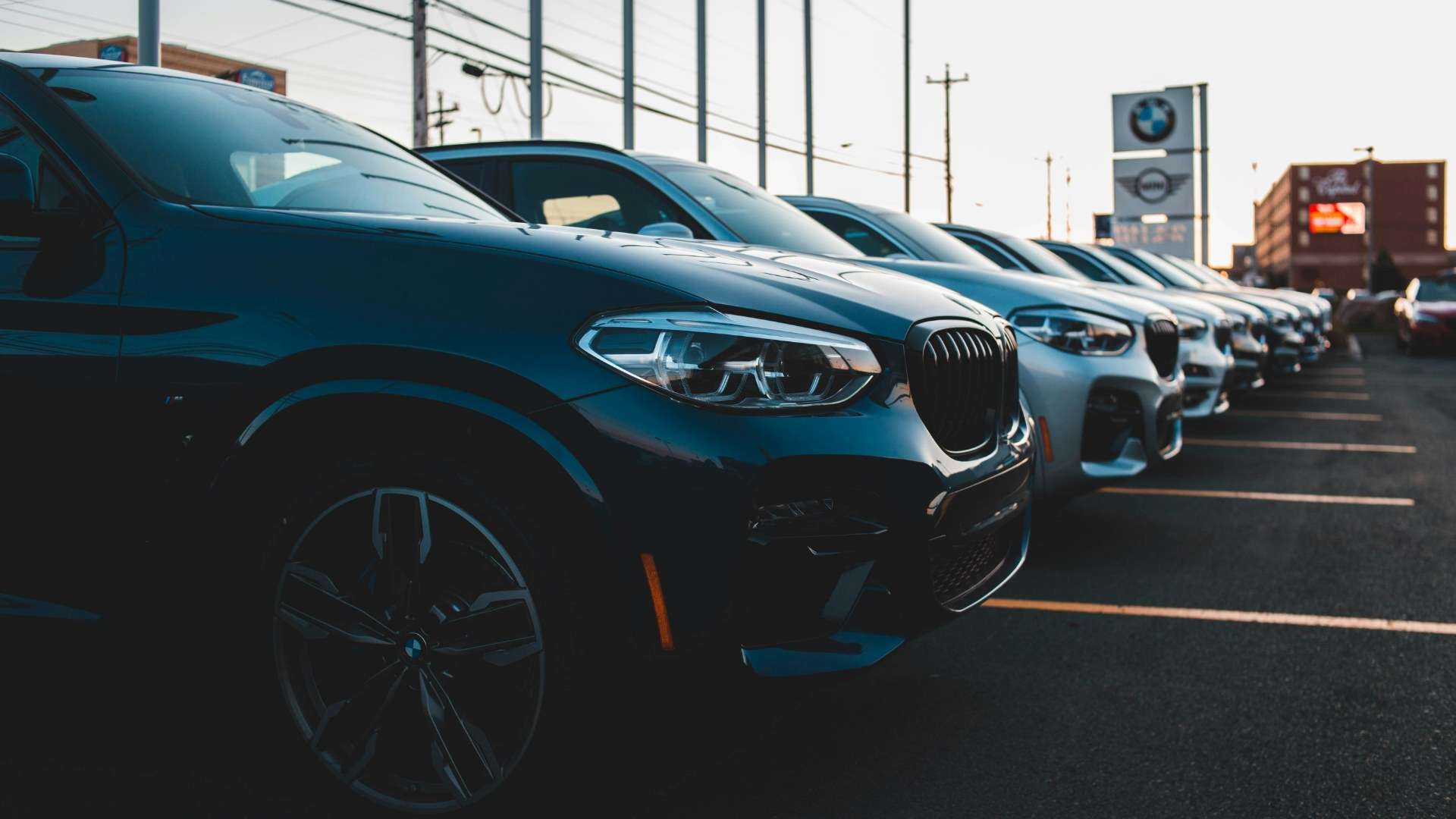 A row of cars for sale parked on a dealership lot